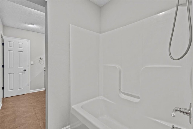 bathroom with baseboards, a textured ceiling, shower / washtub combination, and tile patterned flooring