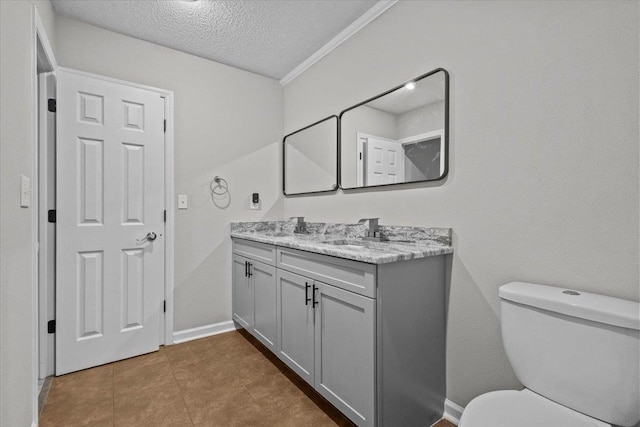 bathroom featuring vanity, baseboards, tile patterned flooring, a textured ceiling, and toilet