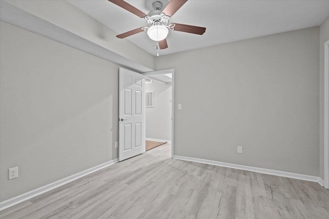 spare room featuring wood finished floors, baseboards, and ceiling fan