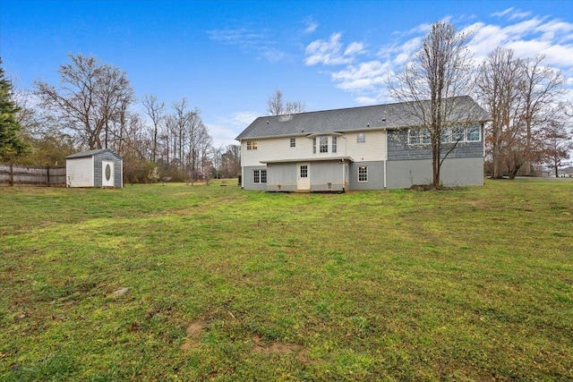 back of property featuring an outdoor structure, a lawn, fence, and a shed