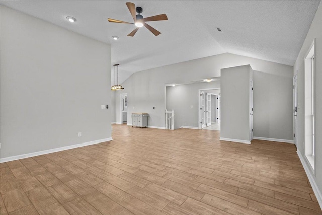 unfurnished living room with baseboards, a ceiling fan, light wood-type flooring, and lofted ceiling