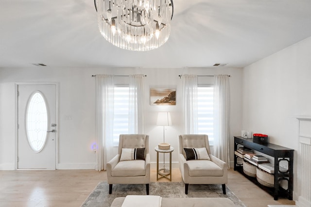 living area featuring light wood-style floors, visible vents, and baseboards