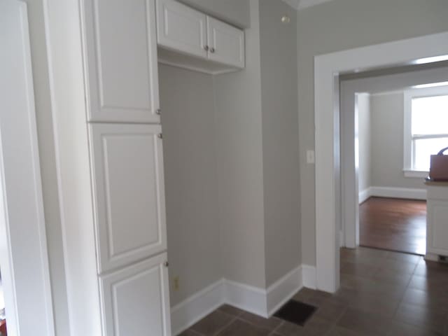 interior space featuring visible vents, baseboards, and dark tile patterned floors