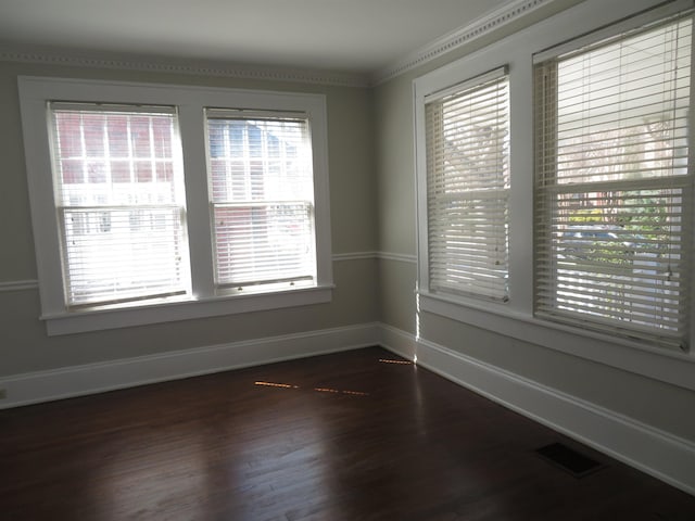 spare room with dark wood-type flooring, baseboards, and visible vents