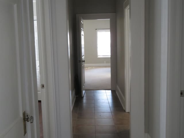 hall with light tile patterned floors and baseboards