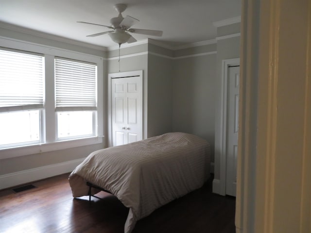 bedroom with visible vents, baseboards, dark wood-type flooring, and crown molding