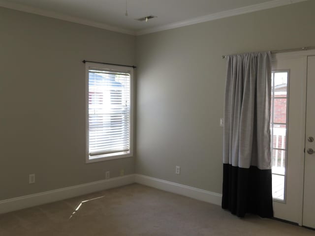 unfurnished room featuring baseboards, plenty of natural light, light carpet, and crown molding