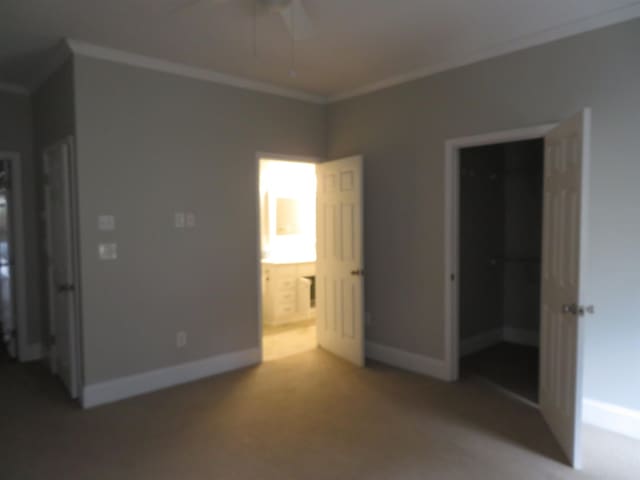 unfurnished bedroom with light colored carpet, ensuite bathroom, baseboards, and ornamental molding