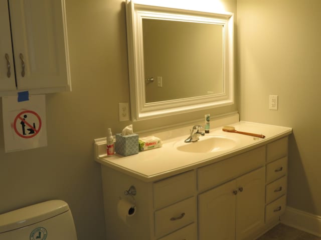 half bathroom with toilet, vanity, and baseboards