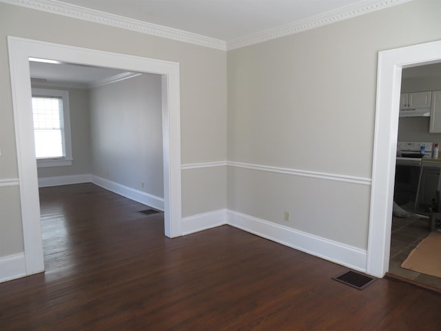 unfurnished room featuring dark wood finished floors, crown molding, and baseboards