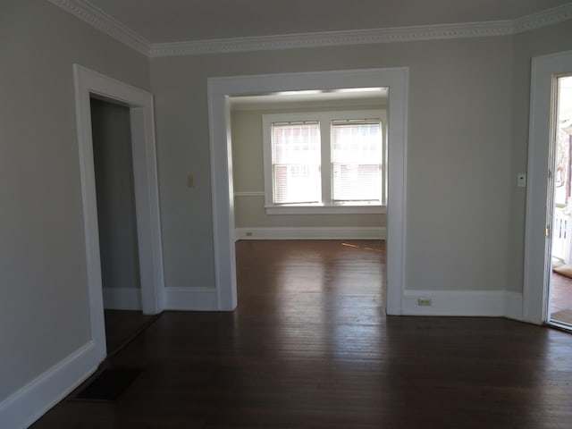 interior space featuring dark wood finished floors, visible vents, baseboards, and ornamental molding