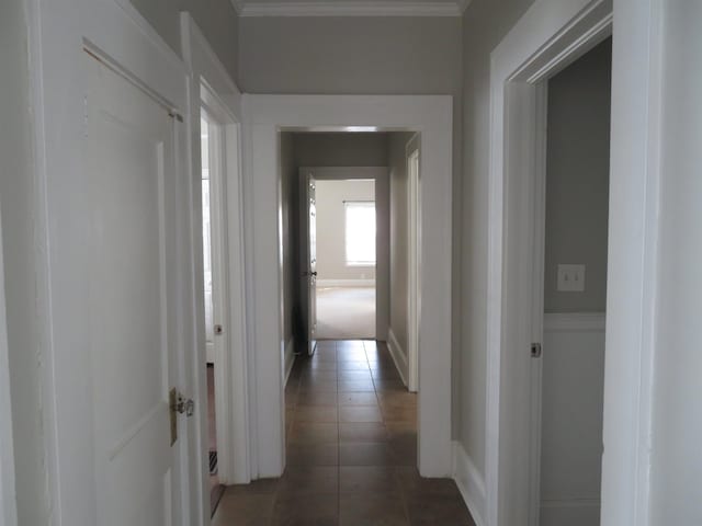 corridor with crown molding and tile patterned floors