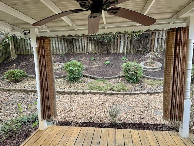 wooden terrace featuring a ceiling fan and fence