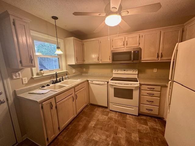 kitchen with hanging light fixtures, white appliances, light countertops, and a sink