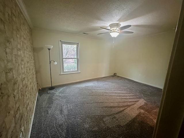 carpeted empty room with a ceiling fan, baseboards, and a textured ceiling