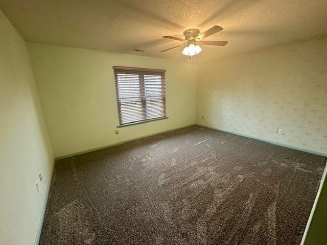 carpeted spare room with ceiling fan, wallpapered walls, baseboards, and a textured ceiling