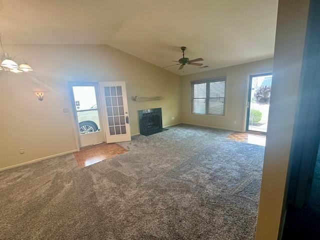 unfurnished living room featuring a fireplace with flush hearth, carpet, baseboards, ceiling fan, and vaulted ceiling