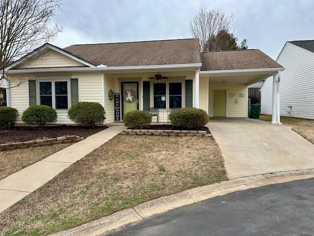 ranch-style home with an attached carport, roof with shingles, and concrete driveway