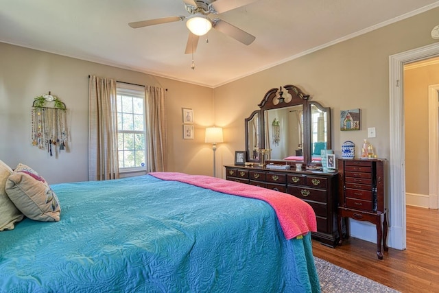 bedroom with ornamental molding, a ceiling fan, and wood finished floors