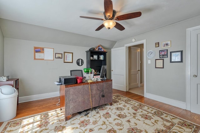 office featuring lofted ceiling, baseboards, light wood-type flooring, and a ceiling fan