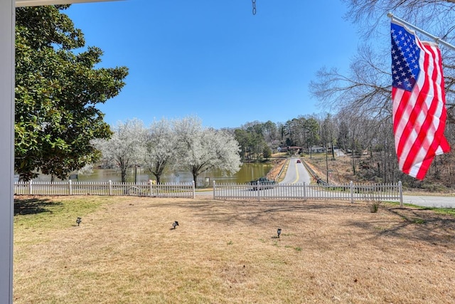 view of yard featuring a water view and fence