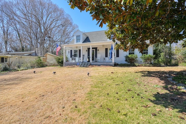 cape cod-style house featuring ceiling fan, a porch, and a front lawn