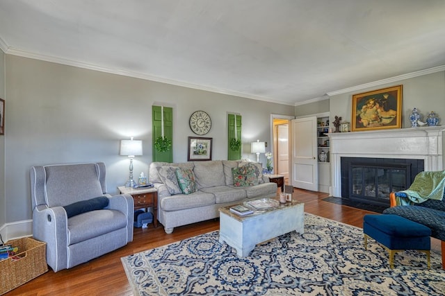 living area with a fireplace with flush hearth, wood finished floors, and ornamental molding