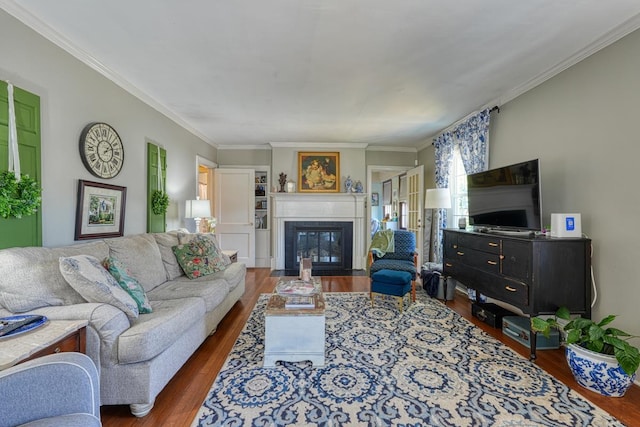 living area featuring crown molding, a fireplace with flush hearth, and wood finished floors