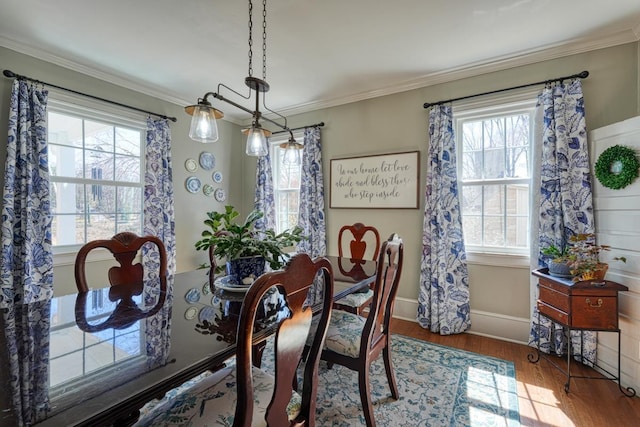 dining area featuring crown molding, wood finished floors, and baseboards