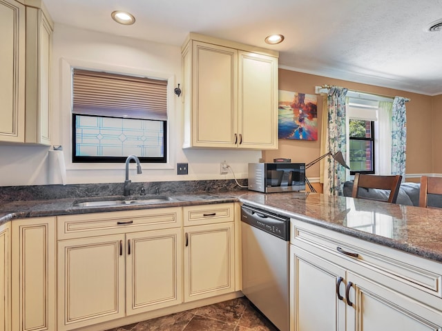 kitchen with cream cabinets, stainless steel appliances, and a sink