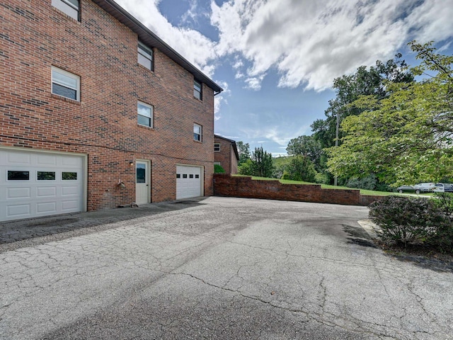 view of side of property with brick siding and an attached garage