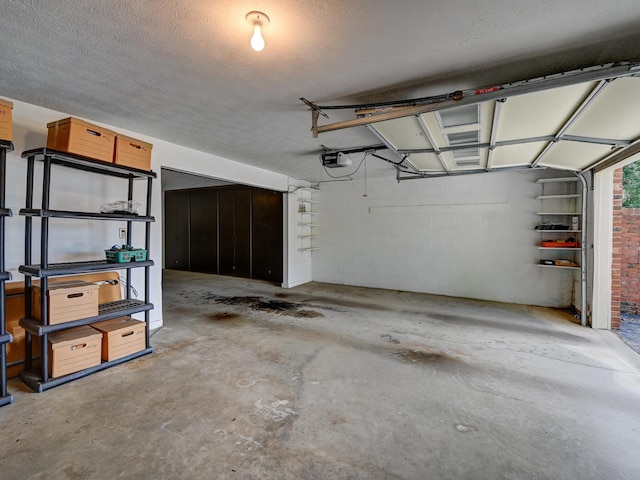 garage featuring concrete block wall and a garage door opener