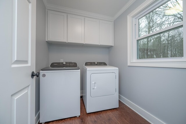 laundry area with ornamental molding, washer and clothes dryer, dark wood finished floors, cabinet space, and baseboards