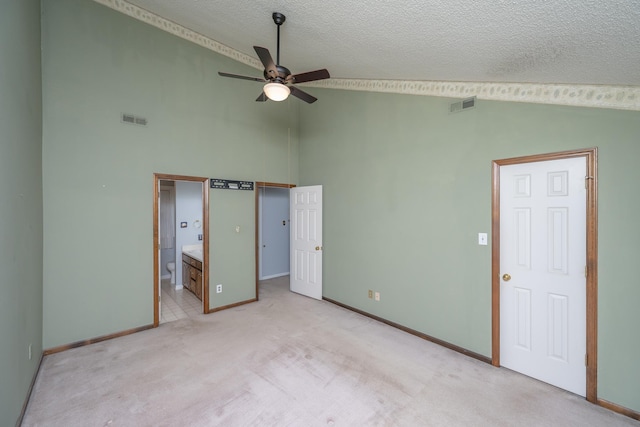 unfurnished bedroom featuring light carpet, visible vents, a textured ceiling, and ensuite bathroom