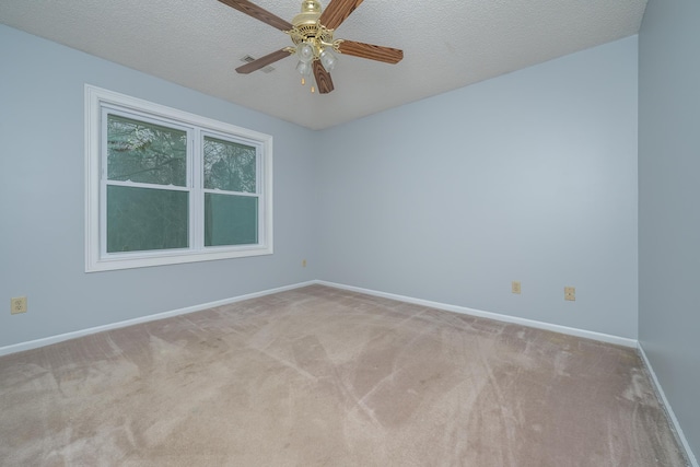 carpeted empty room with ceiling fan, a textured ceiling, and baseboards