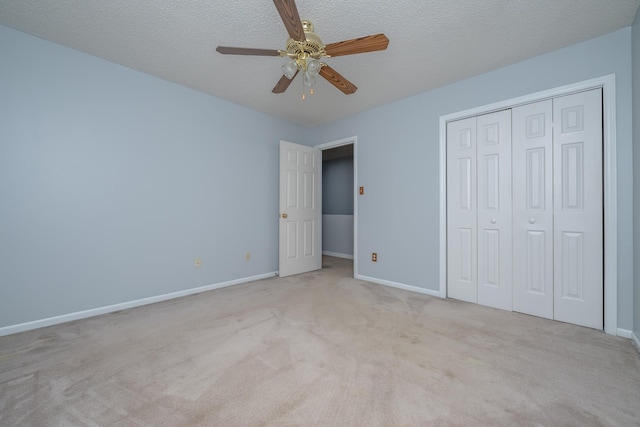 unfurnished bedroom with a closet, baseboards, a textured ceiling, and carpet