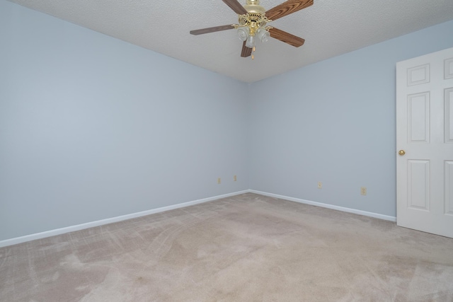 empty room featuring a textured ceiling, a ceiling fan, baseboards, and light carpet