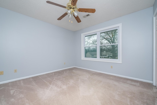 unfurnished room with visible vents, light colored carpet, baseboards, and a textured ceiling