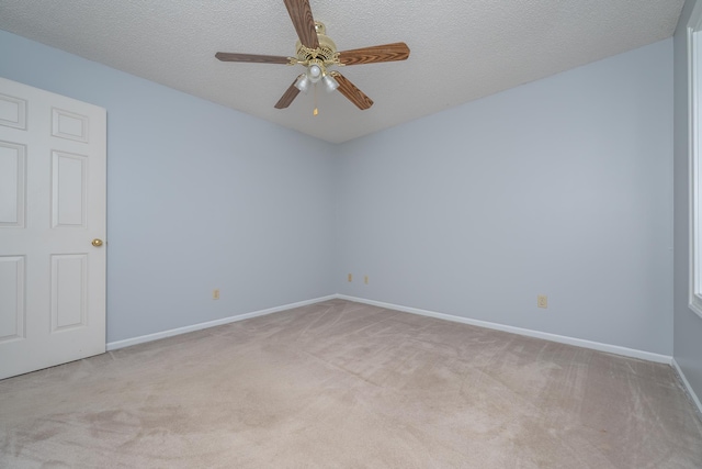 spare room with light carpet, baseboards, a textured ceiling, and a ceiling fan