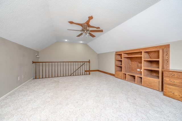 bonus room with a textured ceiling, carpet, a ceiling fan, and vaulted ceiling