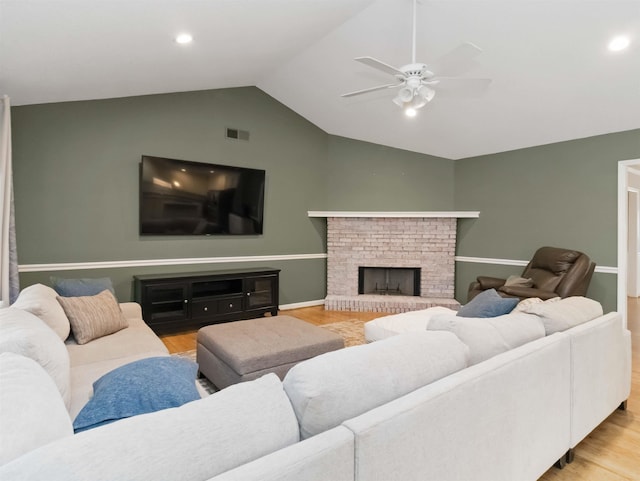 living room featuring wood finished floors, a ceiling fan, visible vents, and lofted ceiling