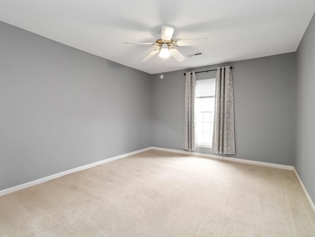 unfurnished room featuring visible vents, baseboards, carpet floors, and ceiling fan