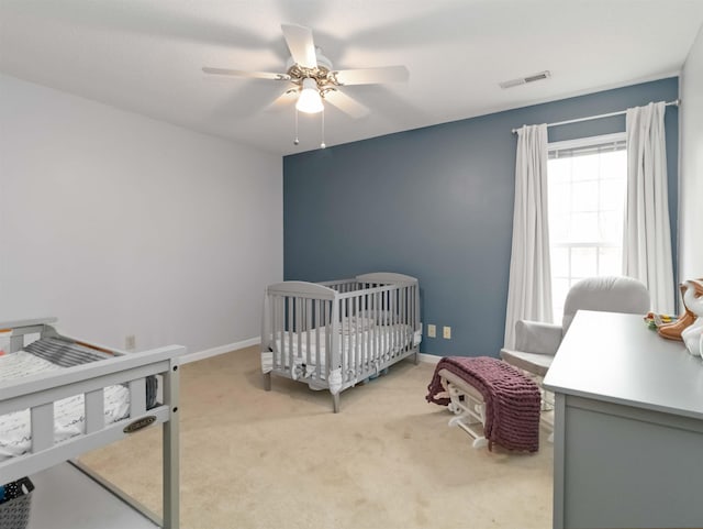 bedroom with ceiling fan, baseboards, visible vents, and light carpet