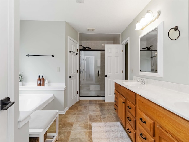 bathroom with visible vents, a sink, a shower stall, double vanity, and a bathtub