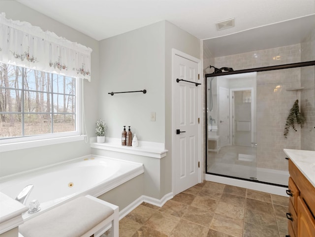 bathroom with vanity, a tub with jets, visible vents, baseboards, and a stall shower