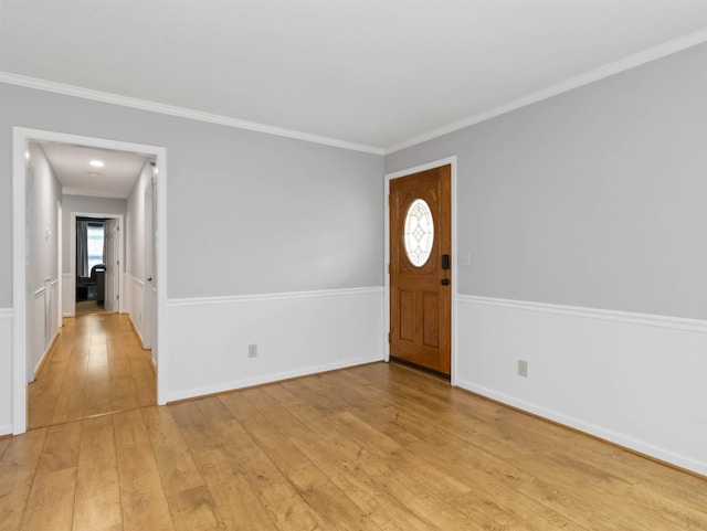 entryway with baseboards, crown molding, and light wood-style floors