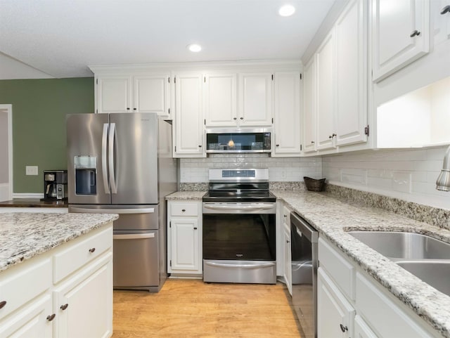 kitchen featuring a sink, white cabinetry, appliances with stainless steel finishes, and light wood finished floors