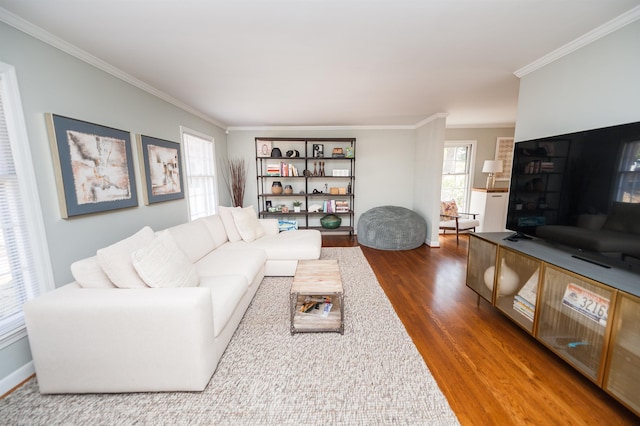 living area featuring baseboards, wood finished floors, and crown molding