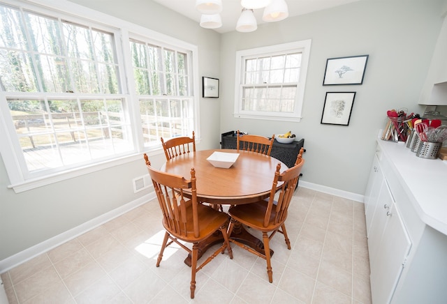 dining room featuring light tile patterned floors, visible vents, baseboards, and a chandelier