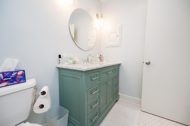 bathroom featuring tile patterned floors, baseboards, toilet, and vanity